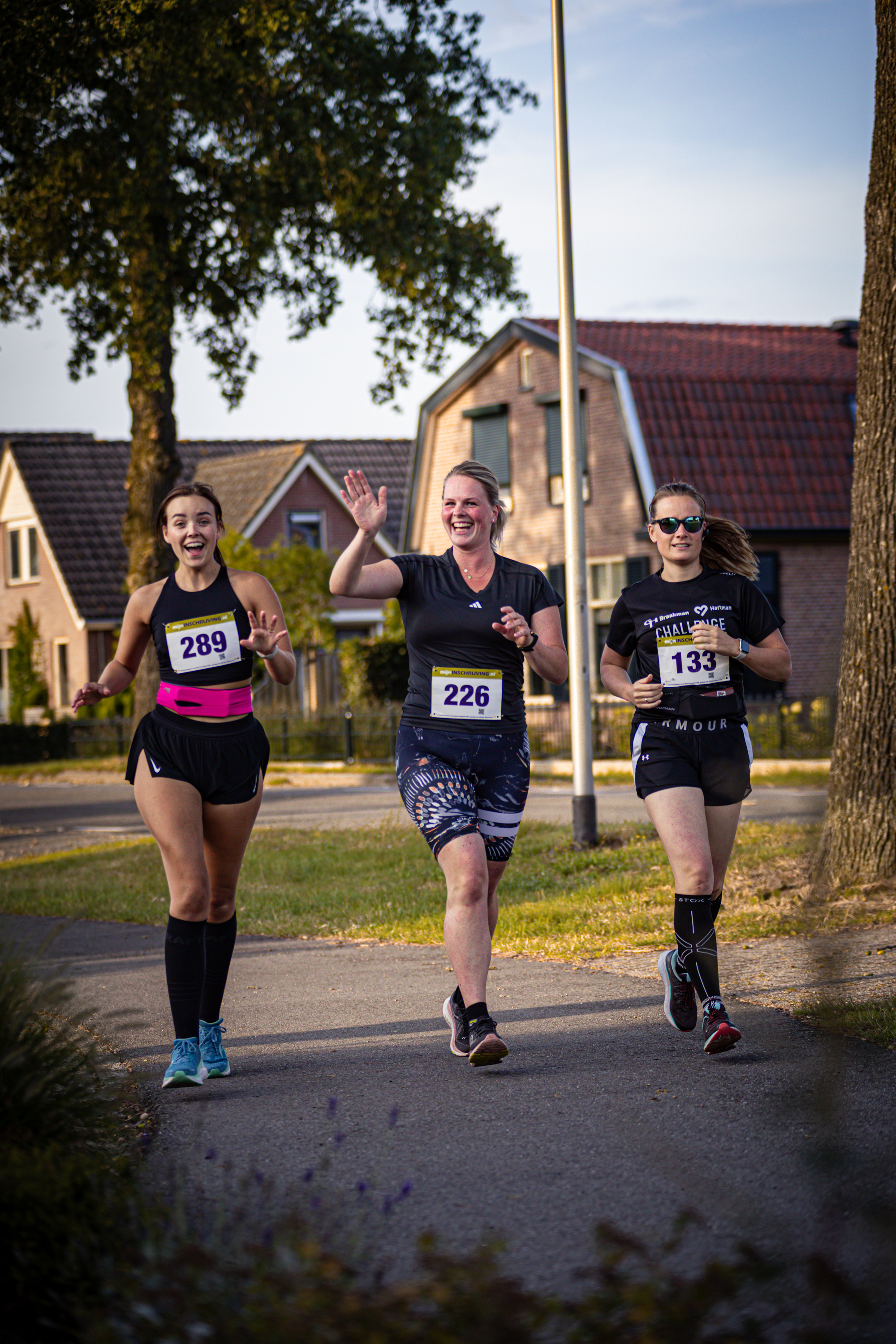 A woman running with a race bib on that reads 228.