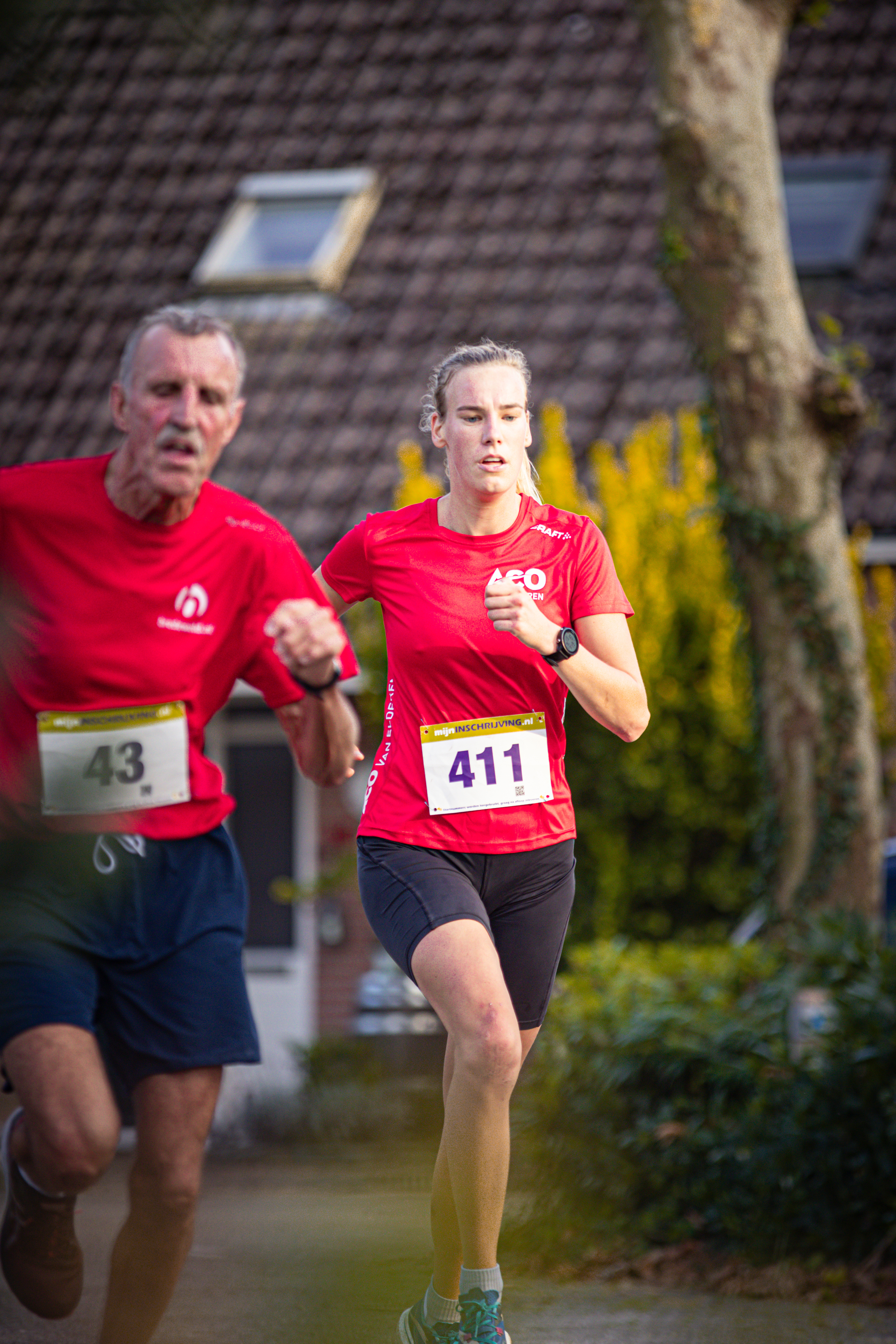 A couple running a race with one wearing a Pomplop.