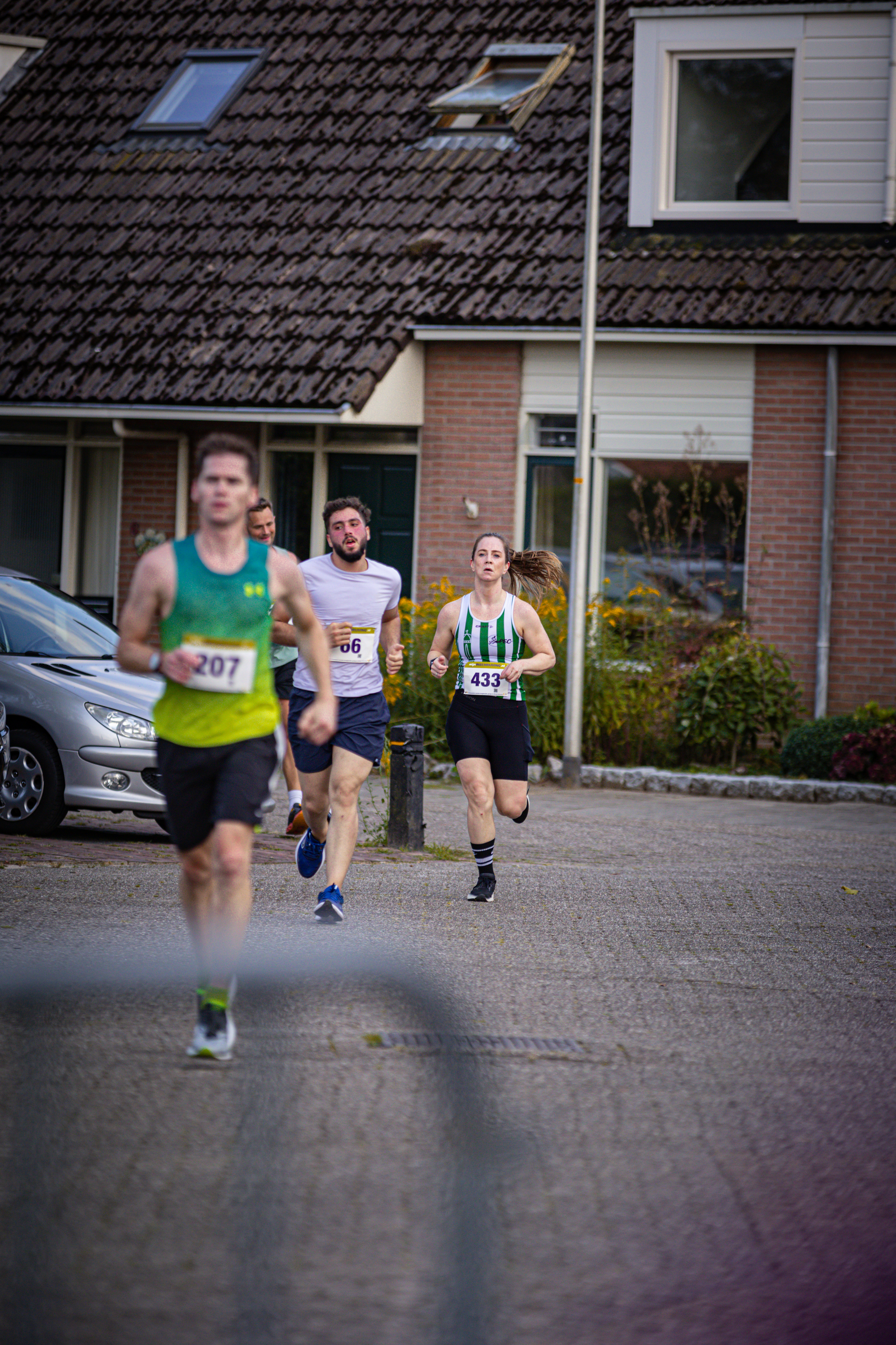 A group of runners compete in a race, with one runner wearing the number 327.