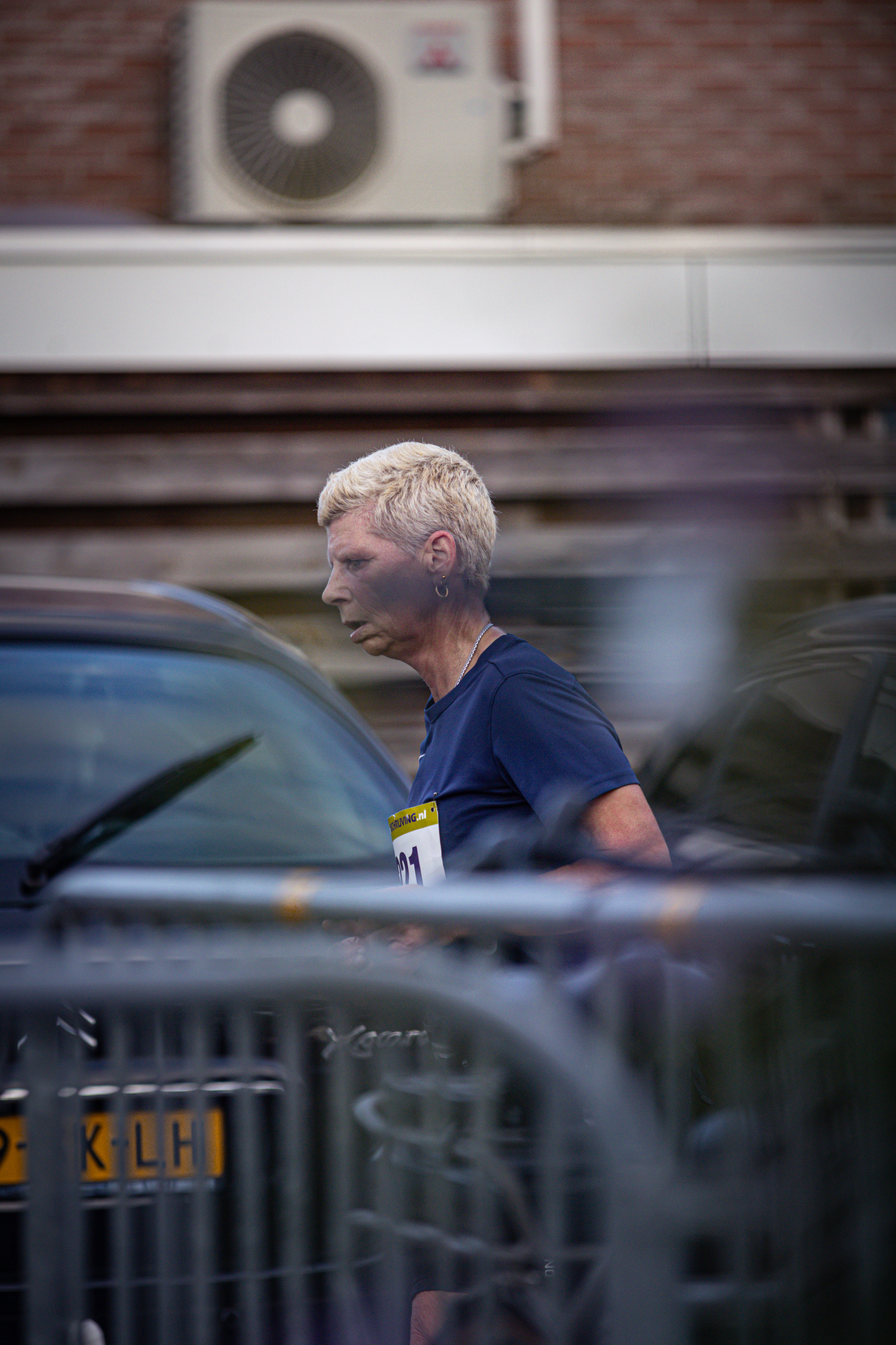 A man with a name tag that starts with "M" looks at the ground and appears to be walking.