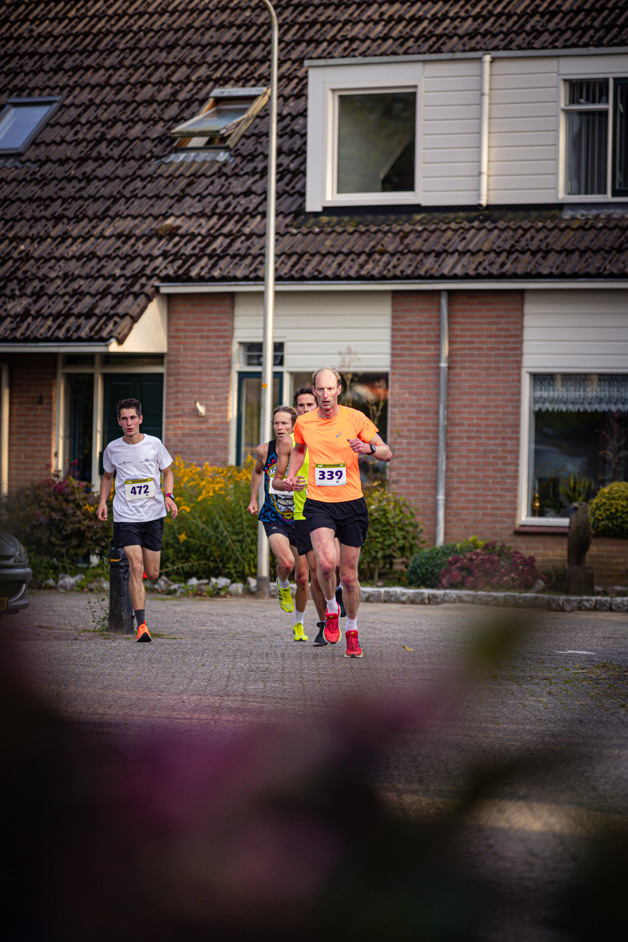 A group of runners participating in a race. One man is wearing the number 345 on his shirt.