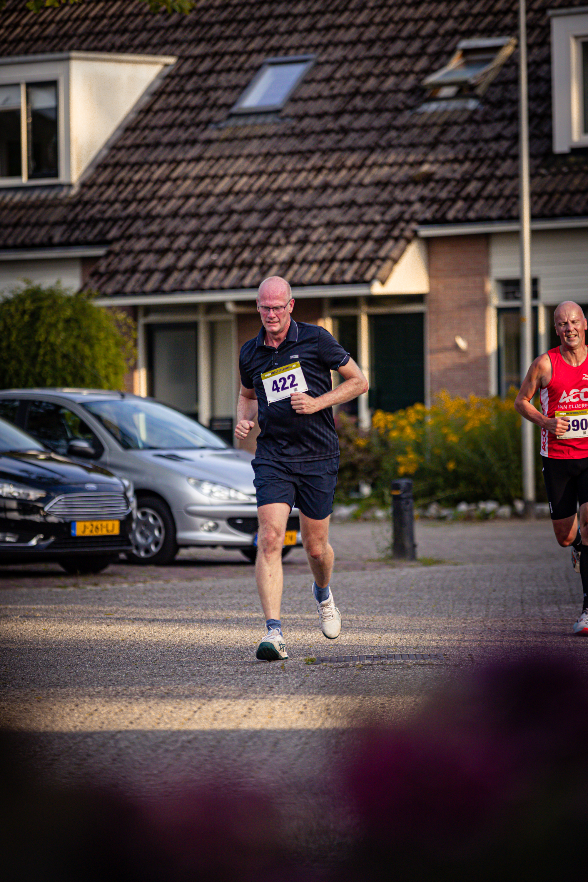 A man runs down a sidewalk with the number 1011 on his shirt.