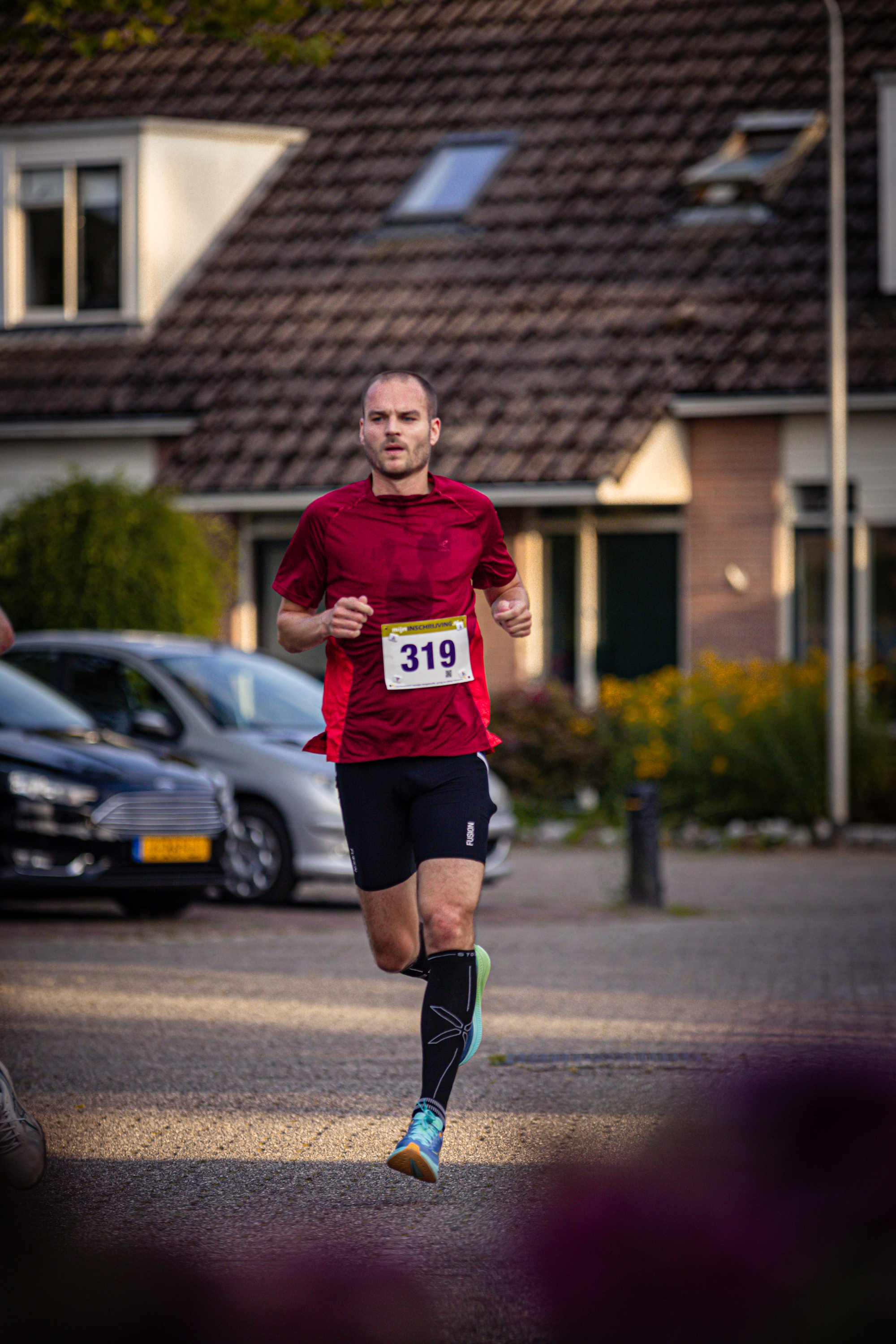 A man running down the street with a number 318 on his shirt.