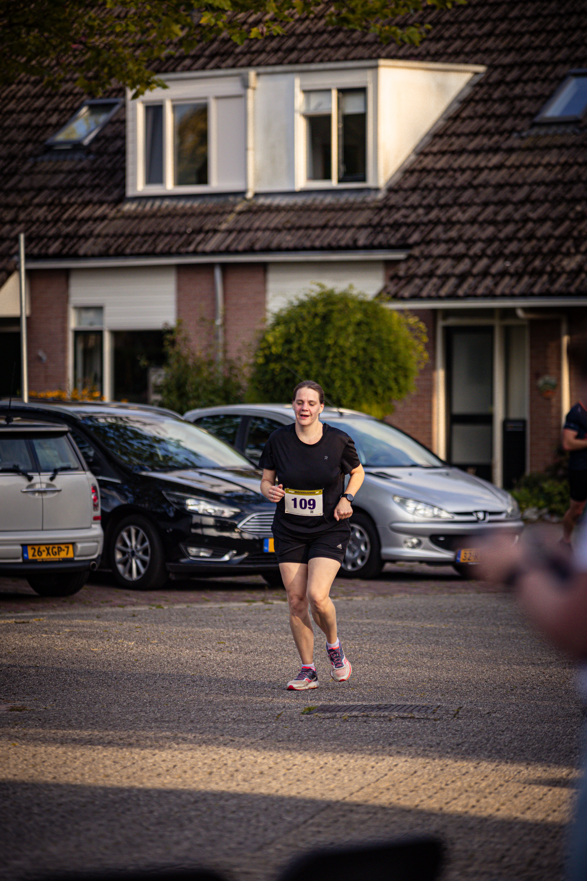 A woman running in a black shirt with the number 109 on it.