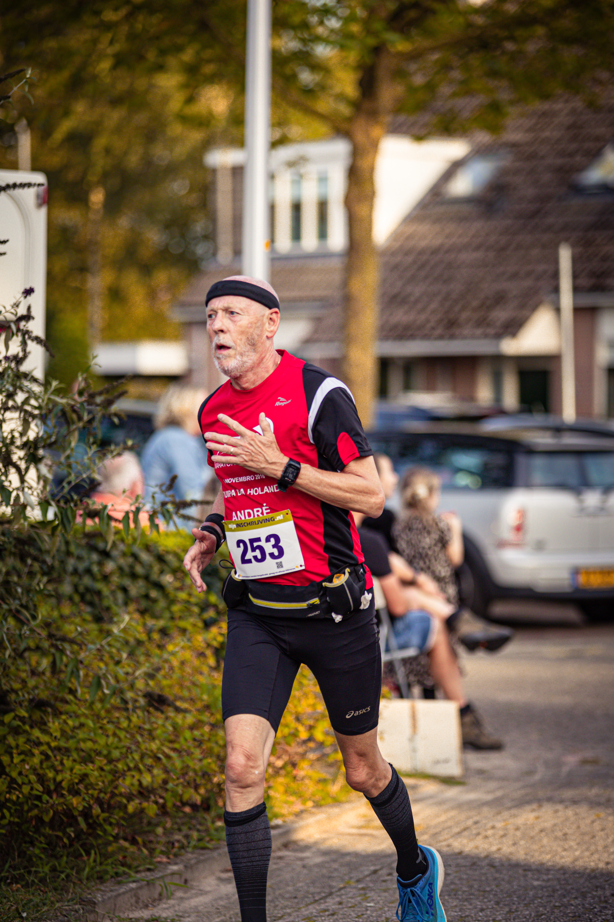 A man wearing a red shirt with the number 525 on it is running.