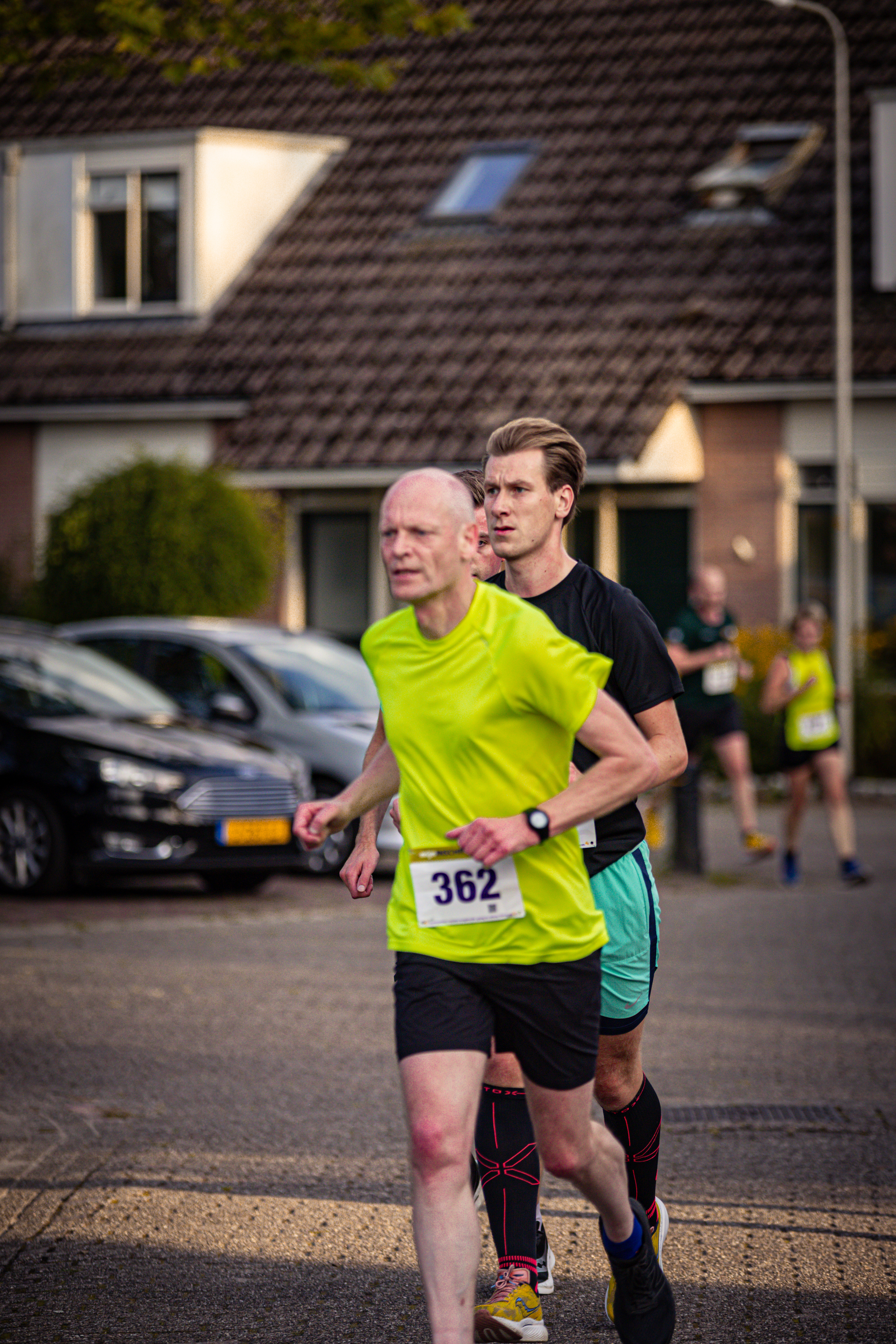 A man in a yellow shirt runs with his family, who also run.