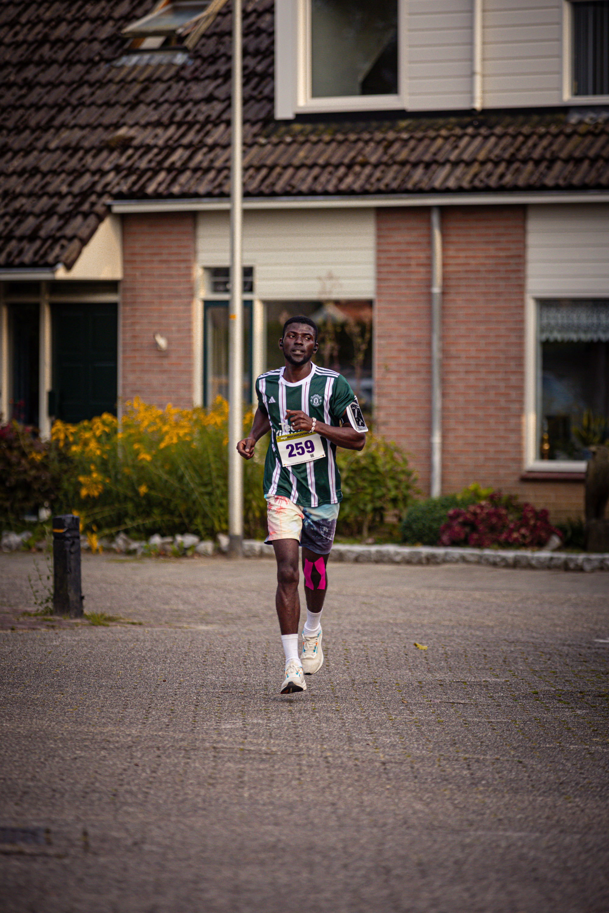 Runner number 2019 in a green and white shirt with pink shorts.