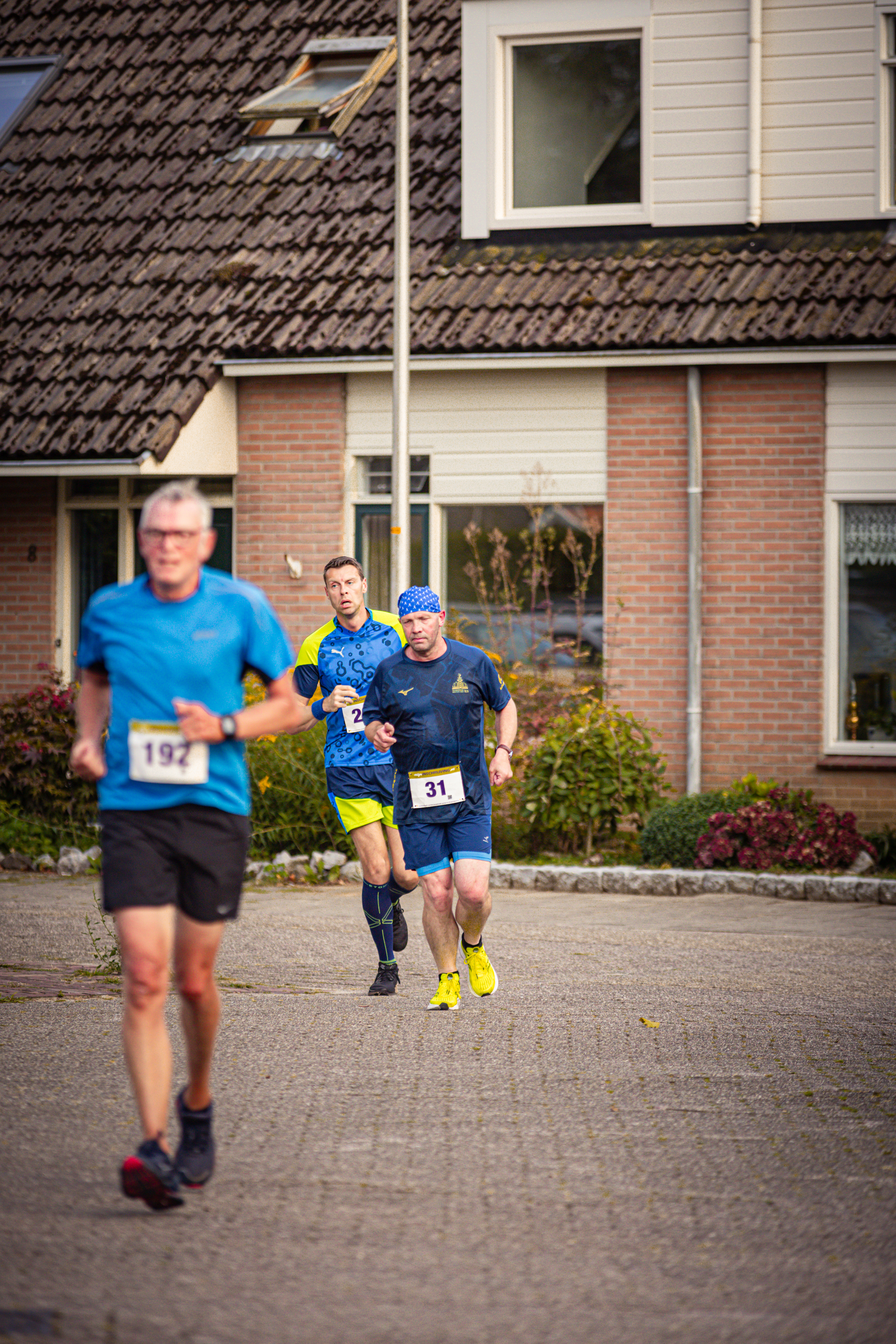 Two men are running in a street with the number 107 and 15 on their shirts.