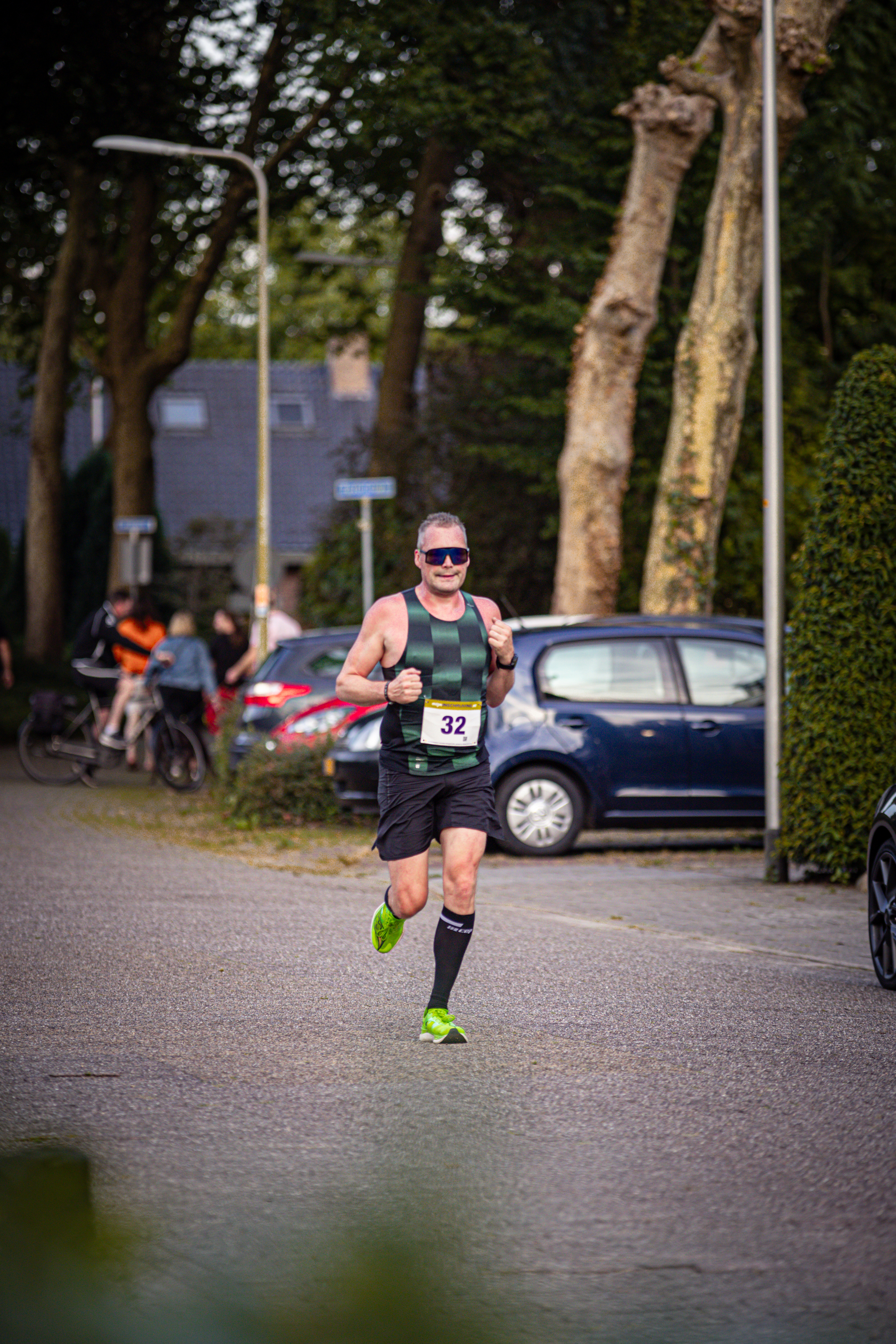 A runner with a yellow bib and number 23 is participating in a marathon.