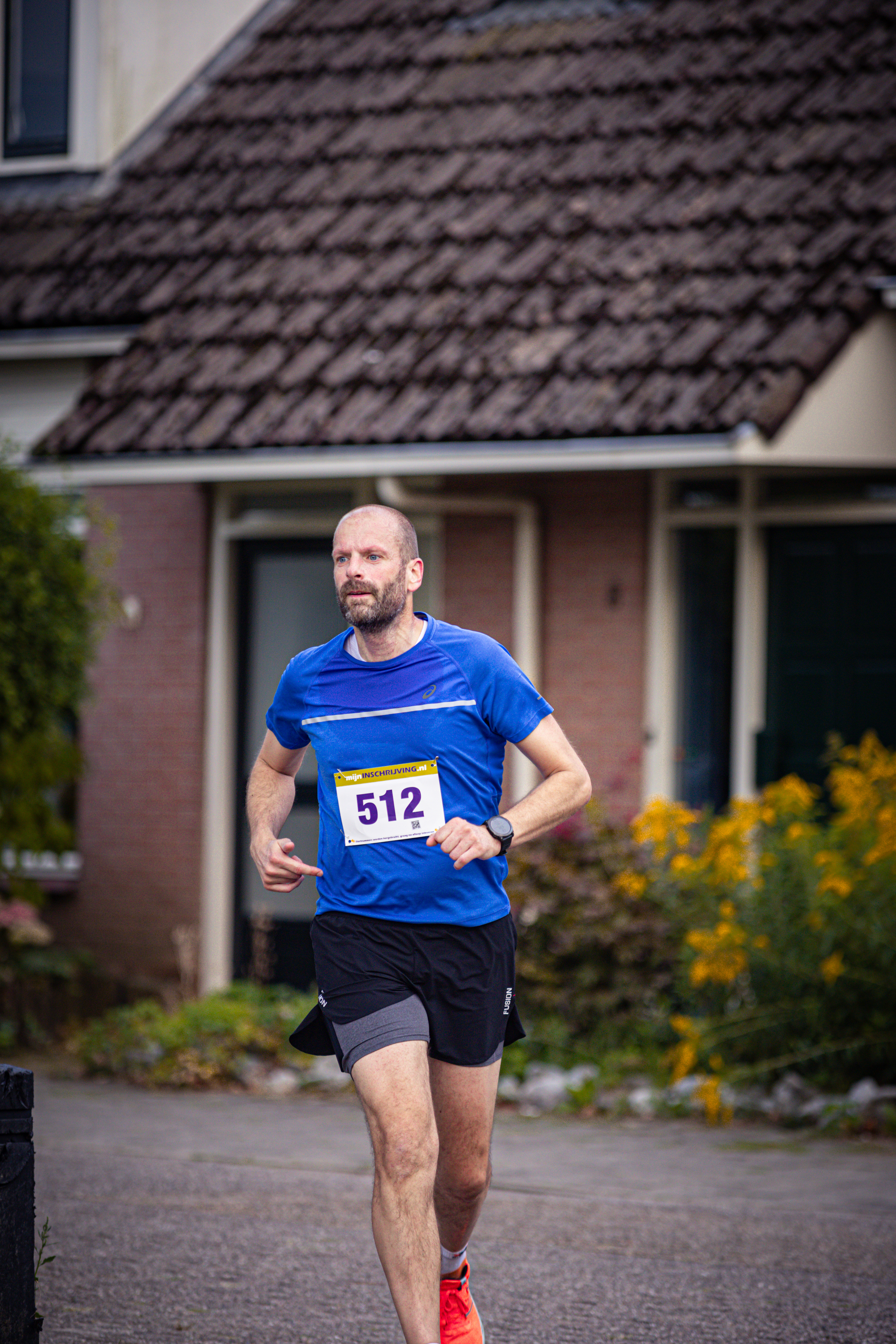 A man running in a blue shirt with the number 512.