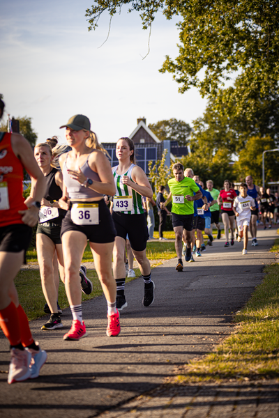A woman running in a marathon with the number 36 on her shorts.