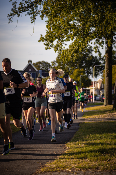 A group of runners wearing bibs numbered 380, 0021 and 238.