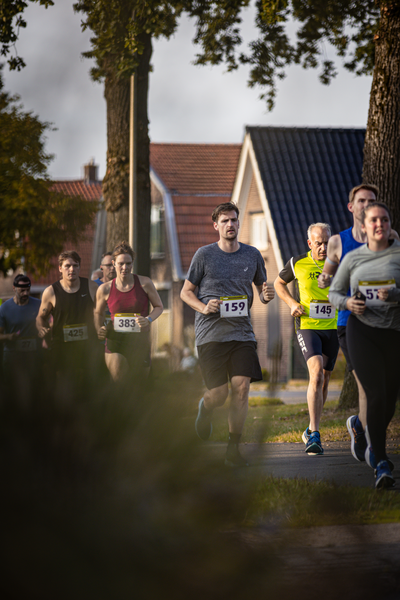 A group of people are running a marathon, with bibs bearing the numbers 175 and 187.