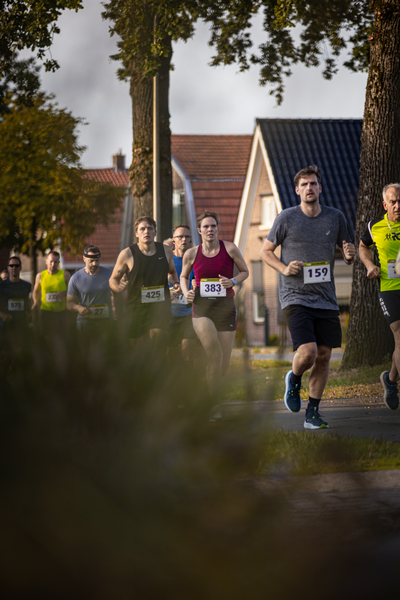 A group of runners participate in a race, with numbers 230 and 139 displayed prominently on their bibs.