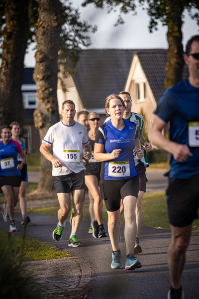 An athlete wearing a blue shirt and shorts numbered 220 on the front of it.