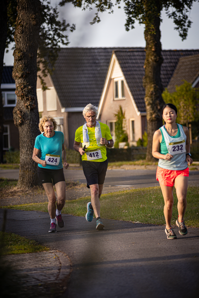 A group of runners participating in a marathon on a sunny day. The runners are wearing bibs with numbers 822, 722, and 828.