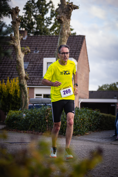 A man running with a yellow shirt and the number 269 written on it.