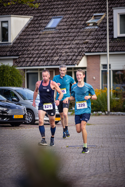 Three people running a race with bibs that say 329, 230 and 240.