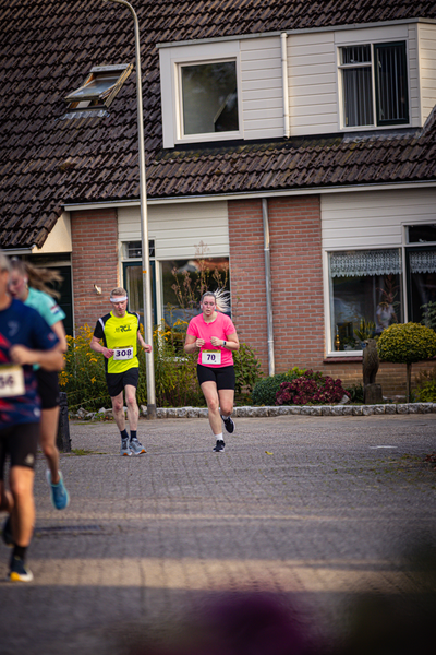 A race is underway on a street with people in brightly colored clothes.