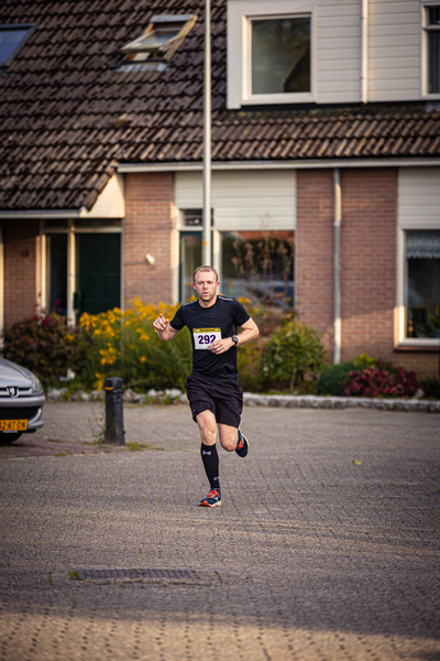 A man running down a street wearing a black shirt with number 249 on it.