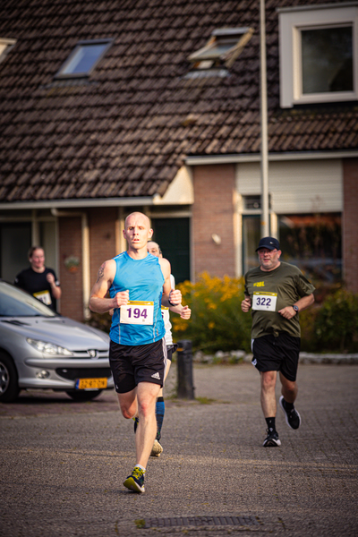 A man running in a blue tank top with the number 194.