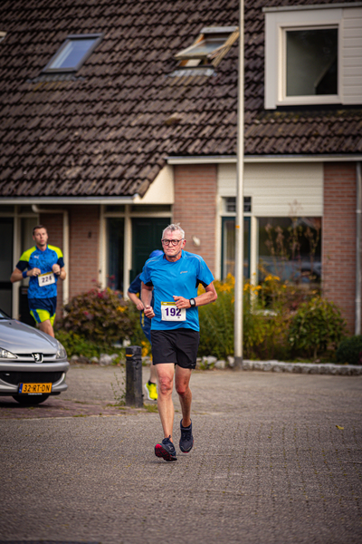 a person running with a blue shirt that has the numbers 138 and 138.