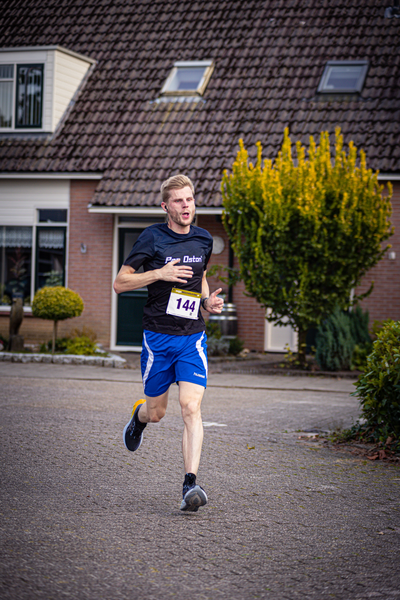 A man running in a black shirt with the words "Pomploop" across the front.