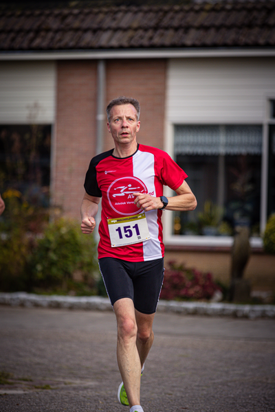 A man running with a red and white shirt that says "Pom" on it.