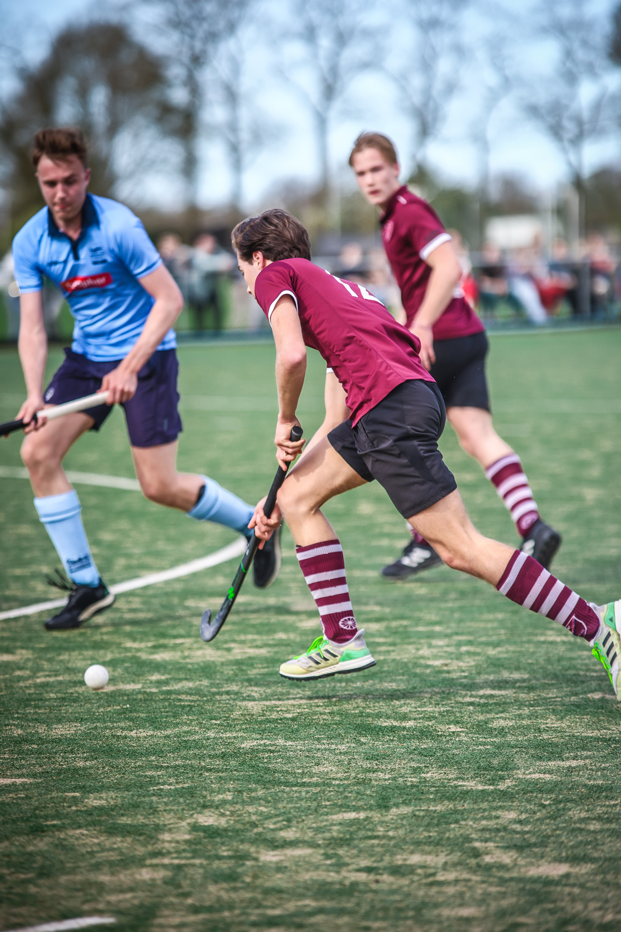 A group of hockey players in action, with one player wearing a red jersey with the number 15 on it.