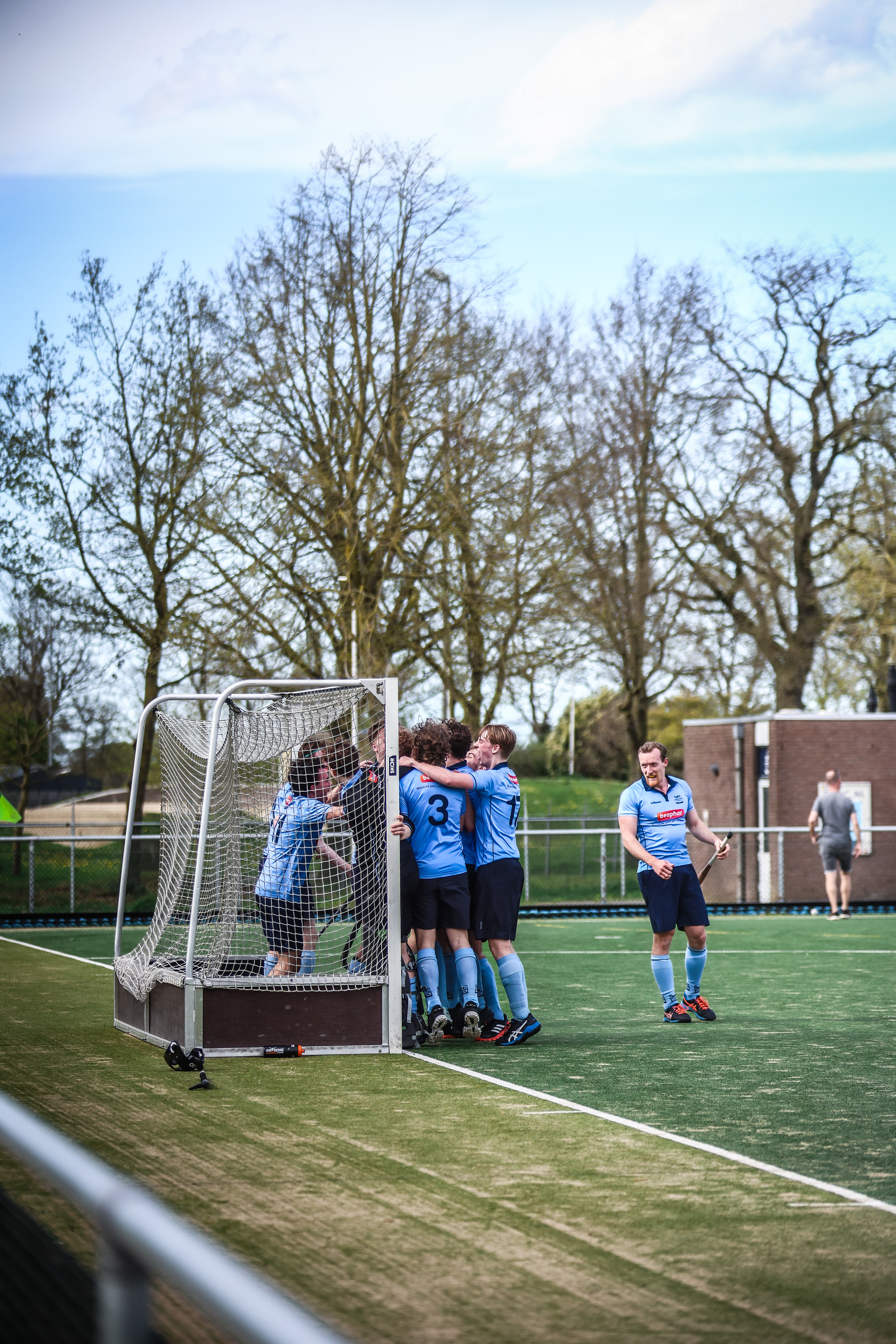 Hockey players celebrate with a teammate on the field.