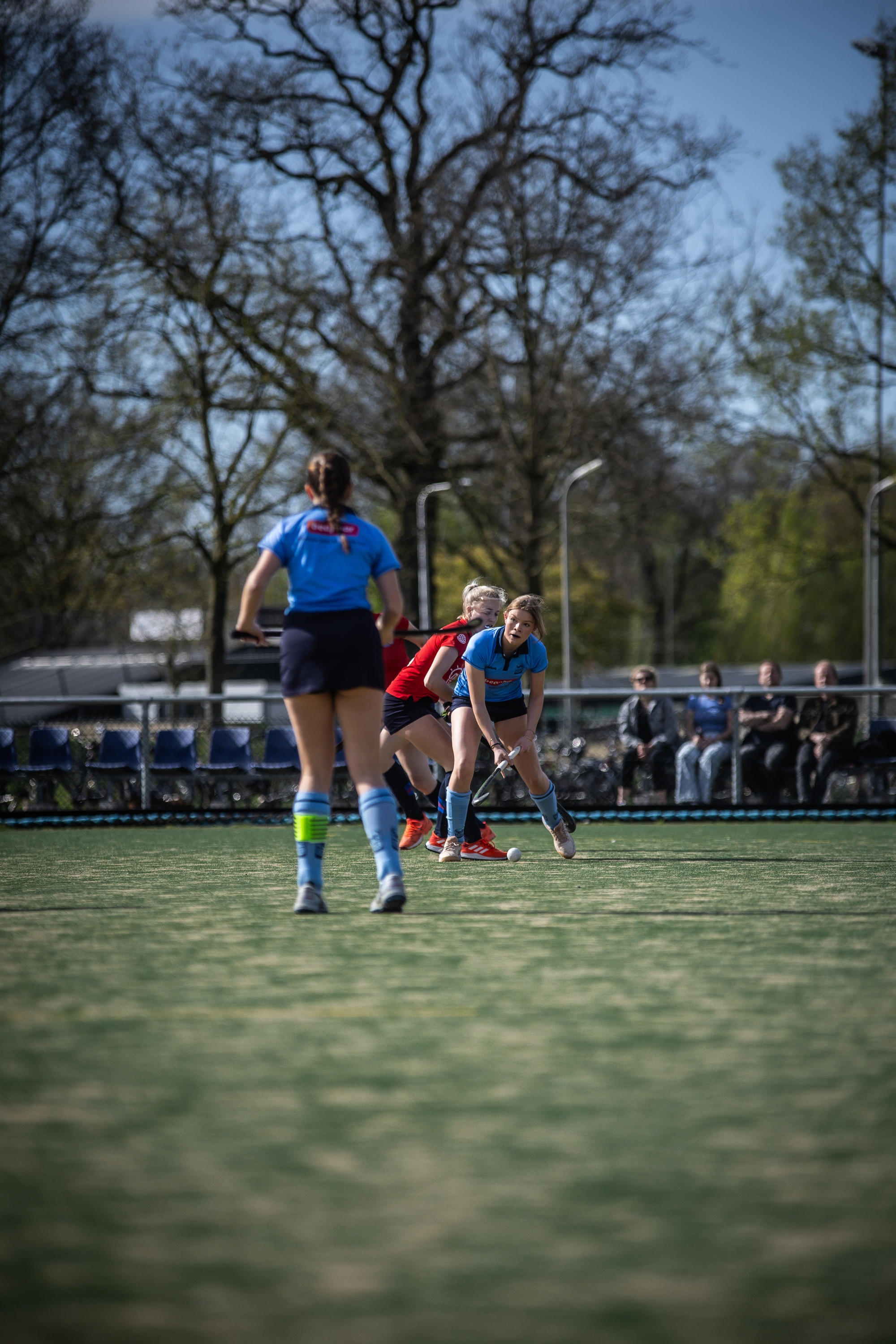 A team of female hockey players compete on a field in 2024.