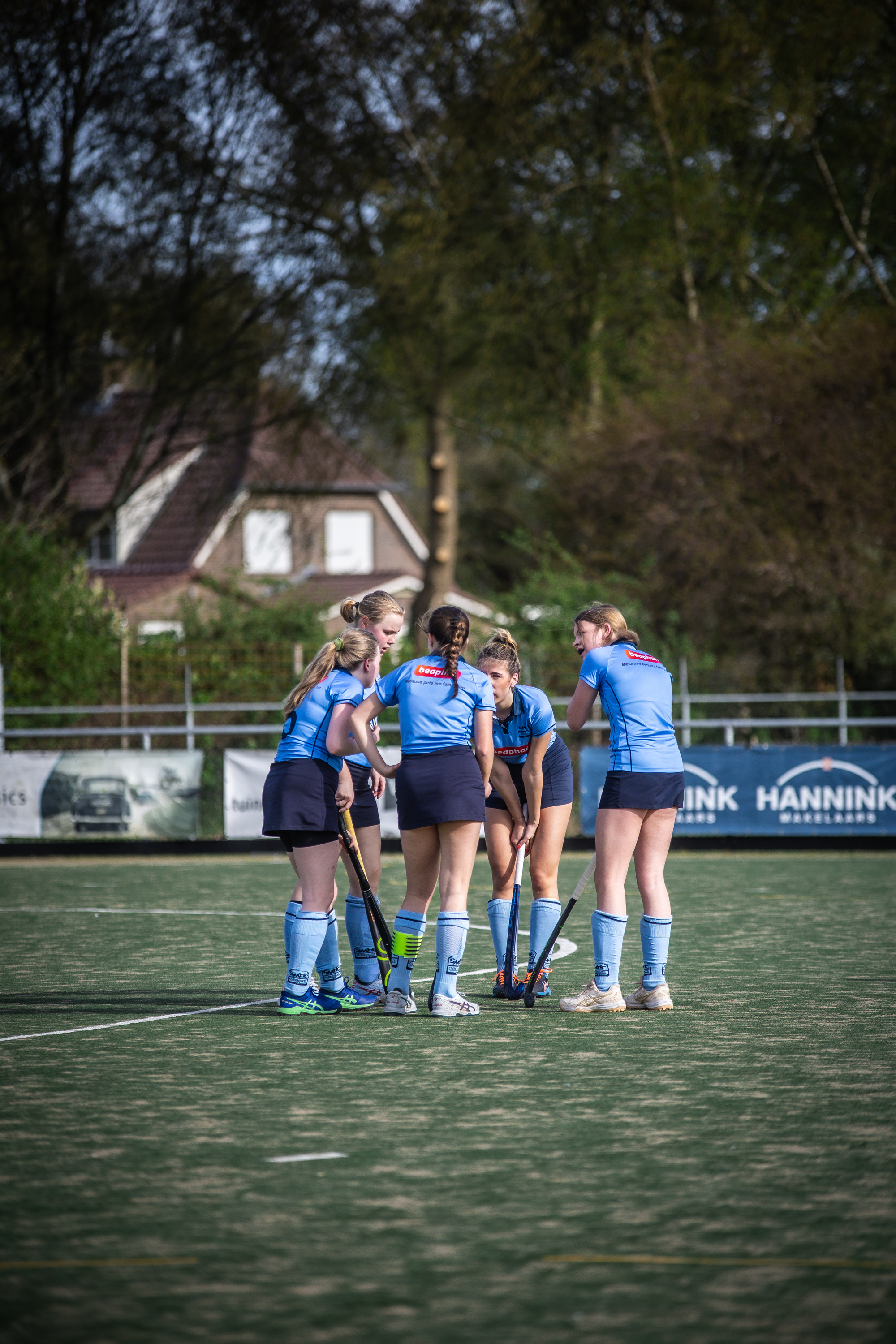 A group of female hockey players wearing blue uniforms and dark shorts.