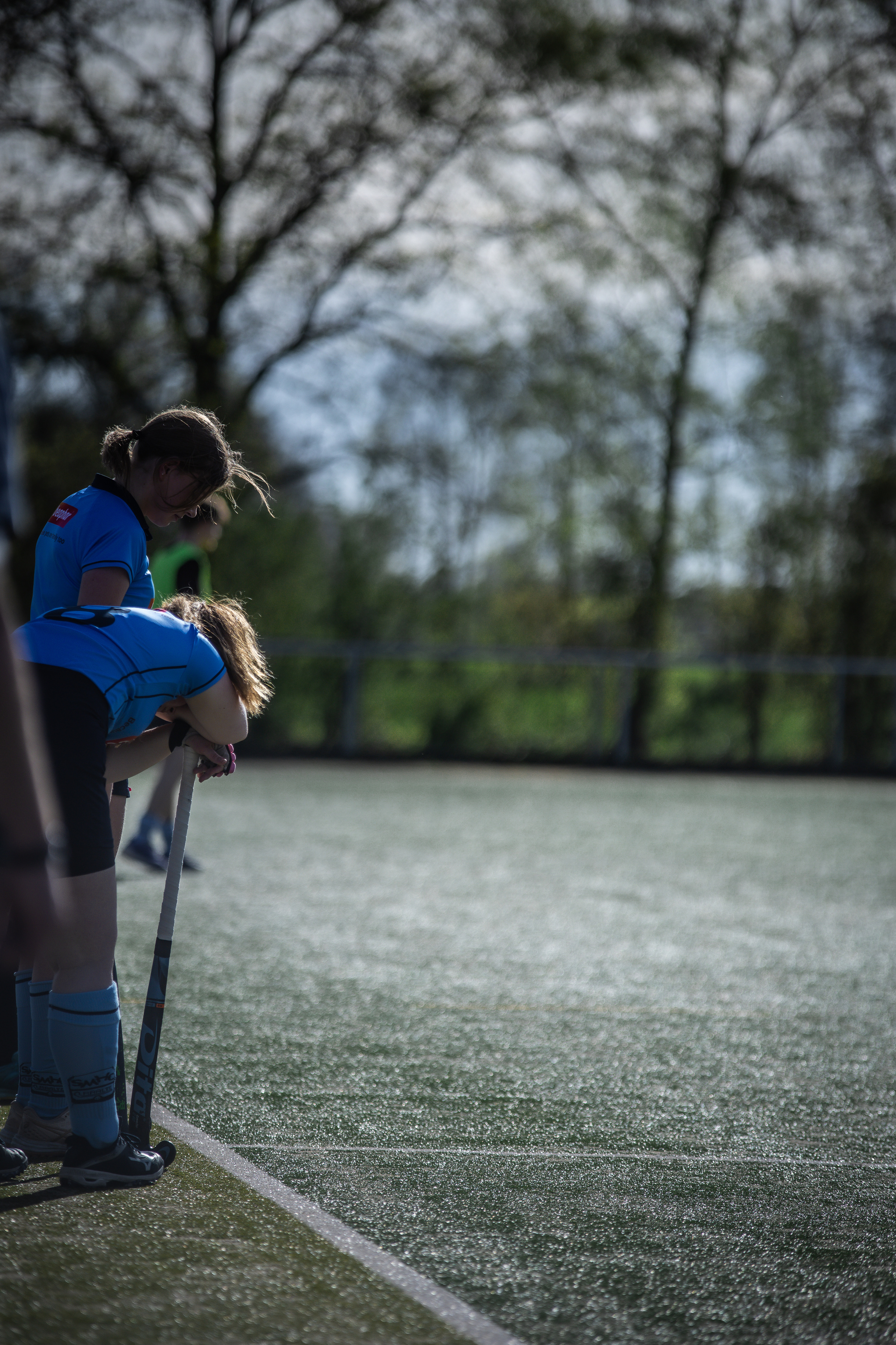 A child in a blue uniform is on a hockey field wearing a helmet with the word "Hockey" printed on it.