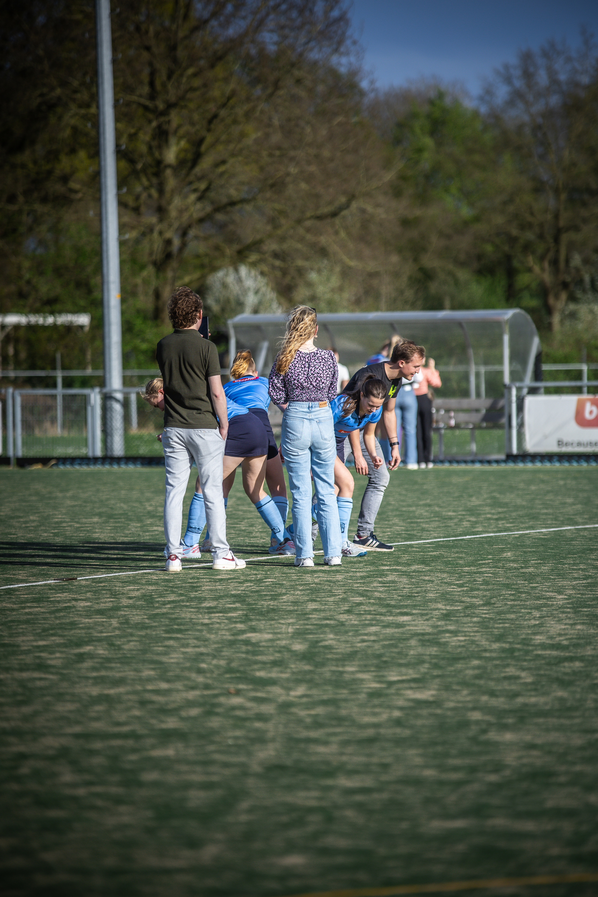 A group of people on a field talking and one is wearing a jersey that says "2024".