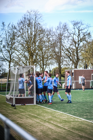 A team of hockey players in blue uniforms gather on the field at the SMHC hockey rink on April 7th, 2024.