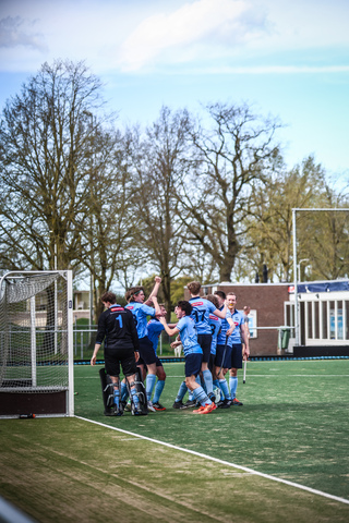 A group of people wearing blue uniforms celebrating on a field with the date 7th April 2024.