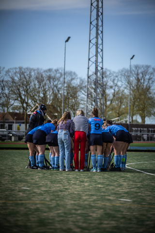 A group of hockey players from SMHC on a field. They are wearing uniforms and huddling up together in unity.