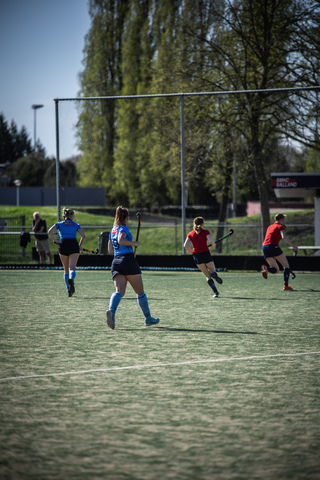 A group of female hockey players on a field with one wearing jersey number 10.