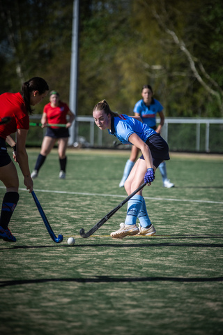 A group of people playing hockey with the name SMHC on it.