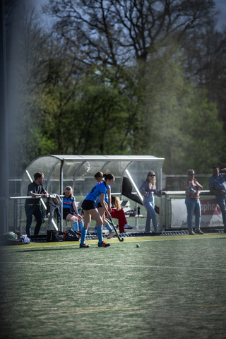 Hockey game taking place on April 7th at SMHC. Players in blue and red jerseys are on the field.