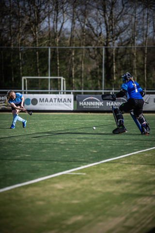 Two hockey players in blue and white uniforms on a field, the player on the right is wearing the number 2.