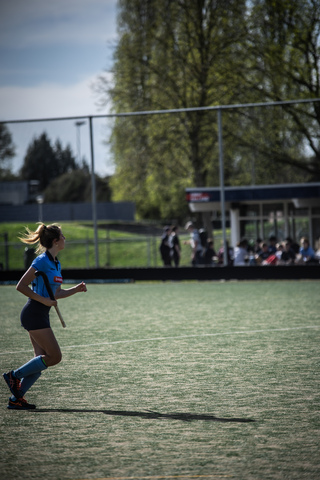 A girl in a blue jersey and shorts is about to shoot the puck into the goal at the SMHC hockey rink.