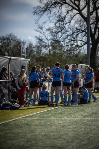 A blue and white hockey team is gathered on the field of play.