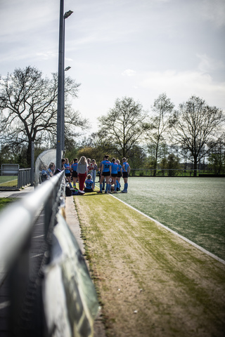 A group of people gather on a field near the starting line for a 2019 SMHC hockey game.