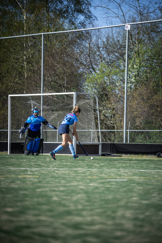 A hockey player in a blue jersey goes after the goal.