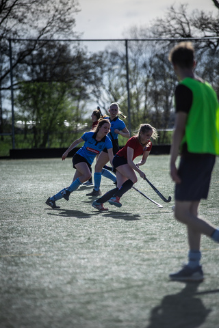 A female hockey game on a field. The players are wearing jerseys that say SMHC.