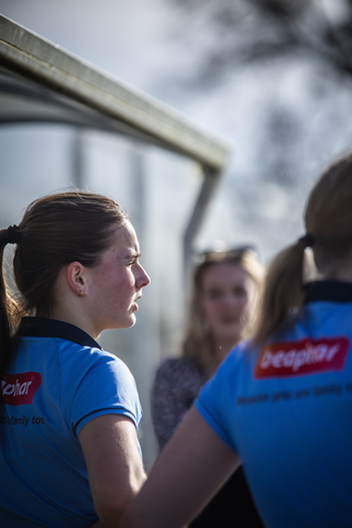 a couple of people standing next to each other with a blue shirt saying 'peoplesport' on the back of it.