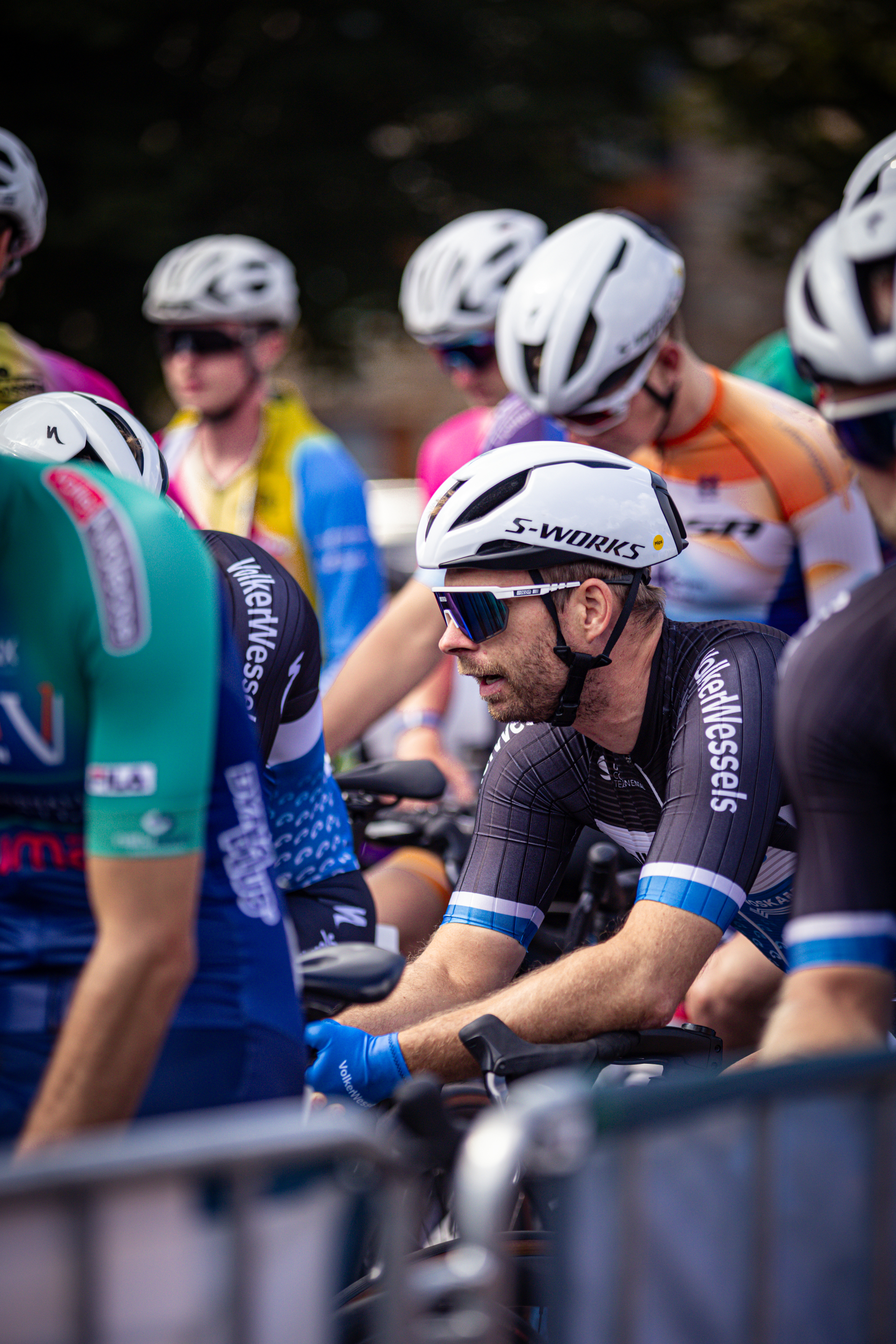 A group of cyclists preparing to race in a competition with one cyclist wearing a number 24.