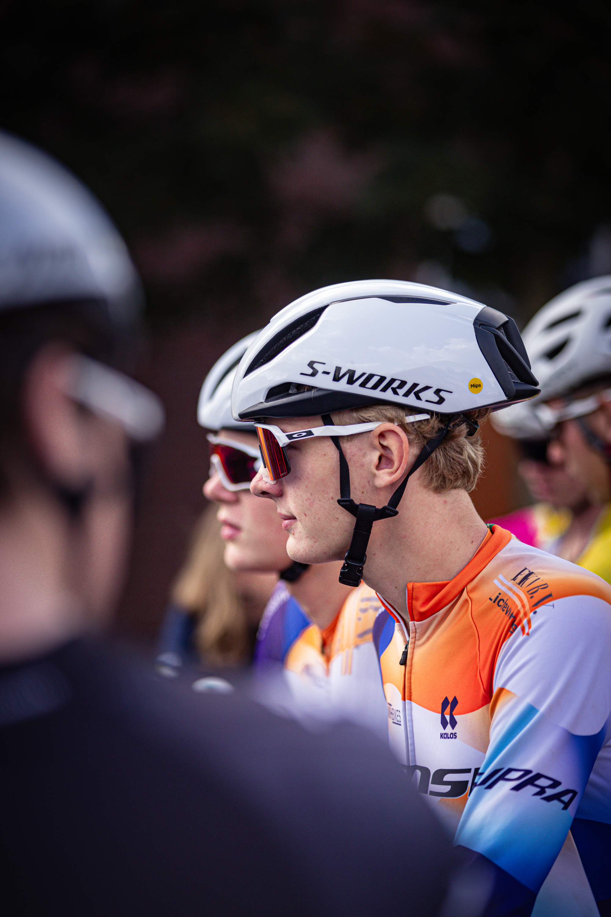 Bicycle racer in a white and orange jersey at the 2024 Tour de France.