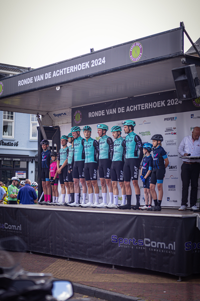 A group of cyclists standing on a platform at the Ronde van de Achterhoek 2024.